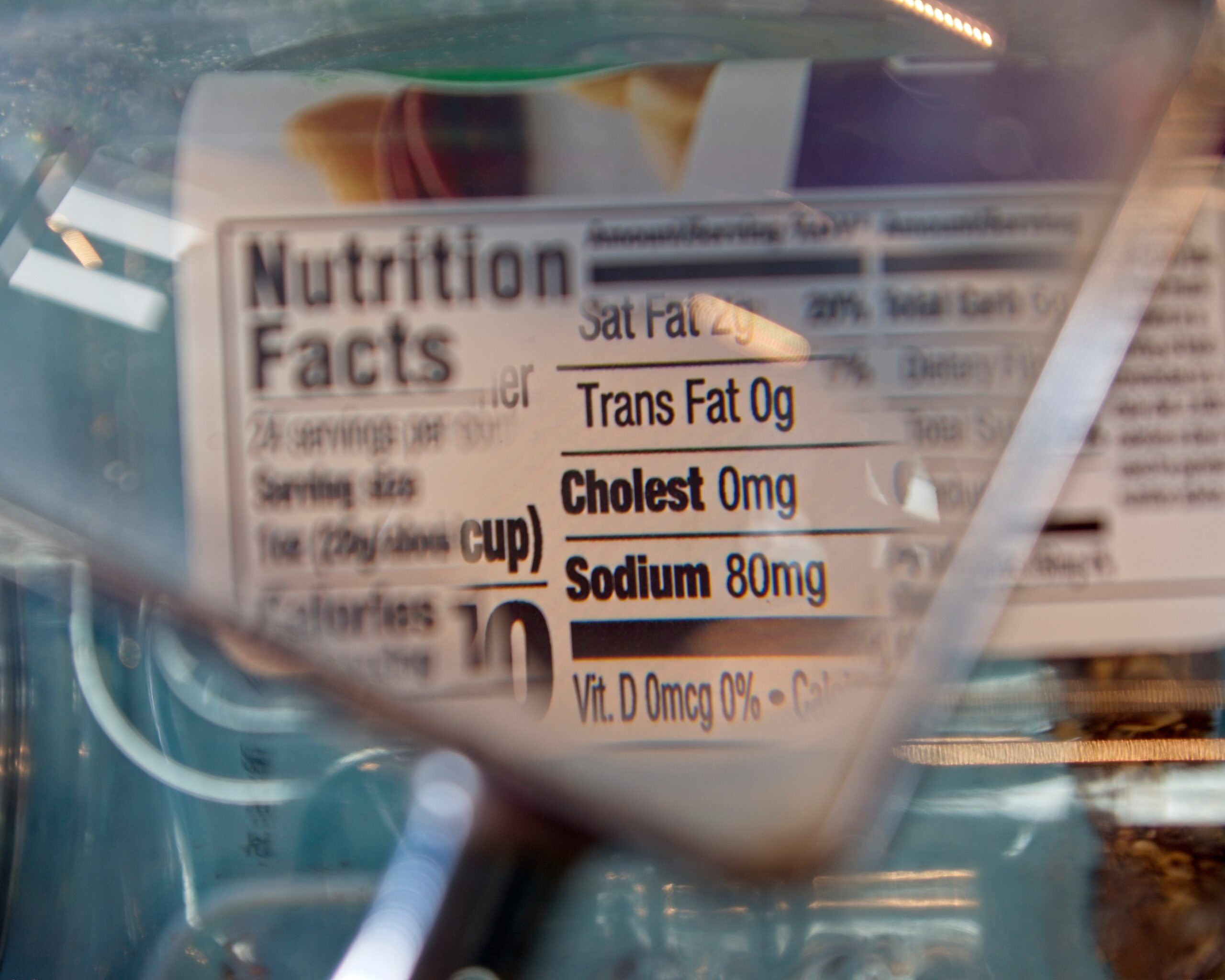 Magnifying glass focusing on cholesterol and sodium on a food label